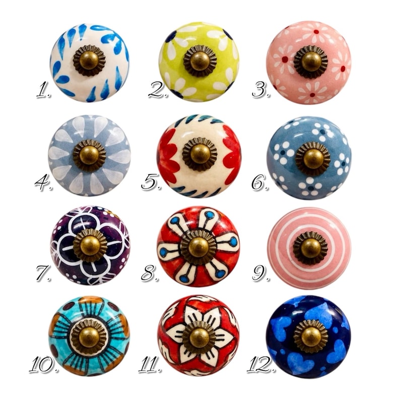 May include: A collection of twelve round ceramic cabinet knobs, each featuring unique hand-painted patterns in various colors including blue, green, pink, red, and purple. Each knob has a central brass-toned metal hardware piece and a number.