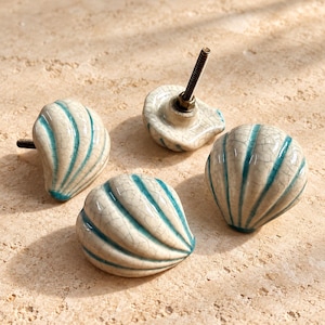 Kastknoppen van schelpkeramiek, ladehandgrepen in crème en turquoise, meubelbeslag in kuststijl