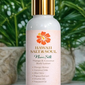May include: White body lotion bottle with a gold cap, labeled "HAWAII SALT & SOUL Nani Silk Mango & Coconut Body Lotion." The label features a hibiscus flower and lists ingredients like mango butter and aloe vera. The bottle contains 4 fl oz / 120 ml.