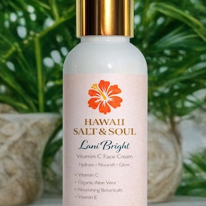 May include: A white bottle of Lani Bright Vitamin C Face Cream with a gold cap. The label features a hibiscus flower and the text "HAWAII SALT & SOUL". The bottle contains 4 fl oz / 120 ml of product.