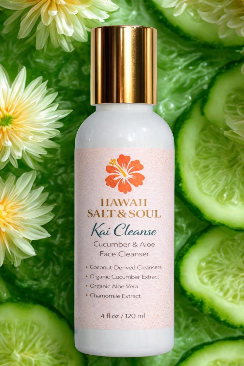 May include: A white bottle of "Hawaii Salt & Soul Kai Cleanse" face cleanser with a gold cap, 4 fl oz (120 ml). The label features a hibiscus flower and the words "Cucumber & Aloe". The background includes cucumber slices and flowers.