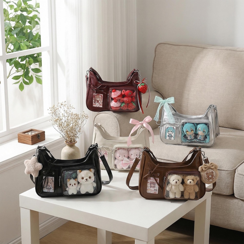 May include: Several shoulder bags in various colors, including black, brown, and silver, are displayed on a white table and a beige sofa. Each bag features a clear front pocket showcasing plush toys and decorative charms. The bags have a rectangular shape.