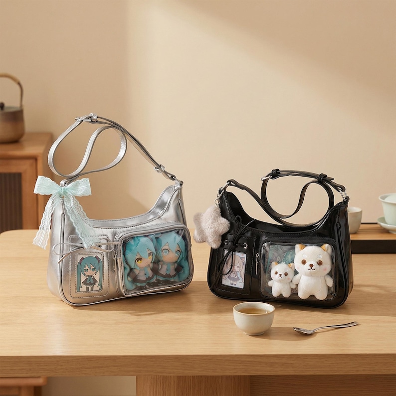 May include: Two shoulder bags on a wooden surface. One is silver with a light blue bow and contains anime figures. The other is black and has a white bear plushie inside. Both bags have clear pockets.