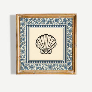 May include: Framed art print with a black and white seashell illustration. The artwork is set against a cream background, framed by a blue border with floral patterns and a gold-coloured wooden frame. Coastal theme.