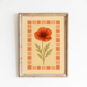 May include: Framed art print featuring a vibrant red poppy flower with a green center and stem, set against a light yellow background. The artwork is framed with a decorative border of orange squares and a rustic wooden frame.