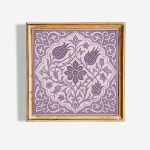 May include: Square framed artwork featuring a symmetrical floral design in shades of purple and lavender. The artwork has a gold-colored frame. The floral pattern includes stylized flowers, leaves, and swirling vines, creating a decorative and elegant aesthetic.