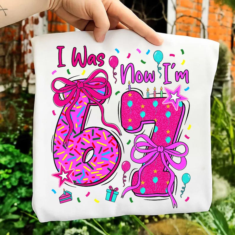 May include: White tote bag with a colorful birthday design. The design features the text "I Was 6 Now I'm 7" in pink, with the numbers decorated like donuts and cake. Pink bows, balloons, confetti, and stars complete the festive look.