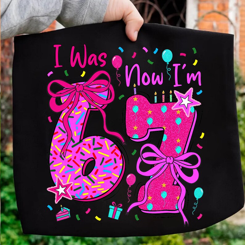 May include: Black tote bag with the text "I Was... Now I'm 67". The numbers are pink with sprinkles and bows. The design includes balloons, confetti, a cake, and a gift box. A fun birthday design.