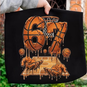 Könnte beinhalten: Schwarze Grafik mit den Zahlen 67, Basketbällen, einem Basketballkorb und einem Basketballplatz-Design. Die Zahlen und Basketbälle haben einen tropfenden, geschmolzenen Effekt. Zwei Hände halten den Basketballplatz.