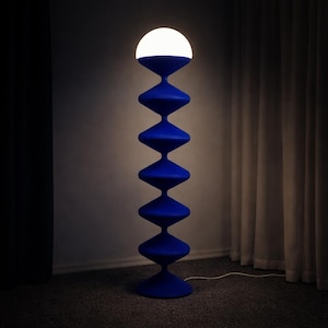 May include: A contemporary blue floor lamp with a unique stacked design. The lamp features a white, spherical light at the top. The lamp is plugged into a wall outlet.