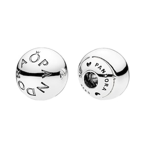 May include: Two silver Pandora charm beads. One bead has the word "Pandora" and a crown engraved on it. The other bead has the word "Pandora" and a heart engraved on it. Both beads are round and shiny.