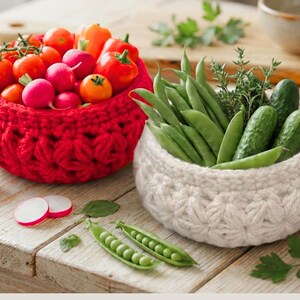 Peut inclure: Deux paniers ronds crochet&eacute;s &agrave; la main avec un motif de points en forme d'&eacute;toile textur&eacute;. Un panier est rouge vif et rempli de tomates rouges, de radis et de poivrons orange. L'autre est blanc cass&eacute; et contient des haricots verts, des concombres et des herbes.