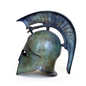 May include: A bronze Greek warrior helmet with a plume on top. The helmet is a replica of an ancient Greek helmet and is a popular decorative item.