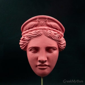 May include: A pink plaster bust of a woman with a crown of birds and a floral design. The bust is a replica of a classical Greek sculpture.