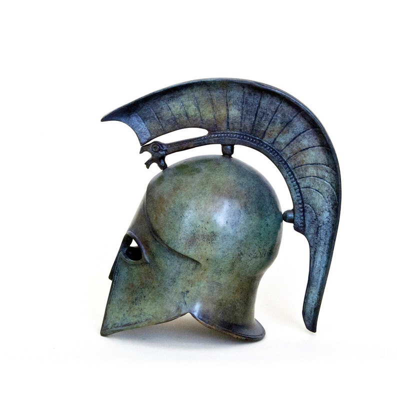 May include: A bronze Greek warrior helmet with a plume on top. The helmet is a replica of an ancient Greek helmet and is a popular decorative item.