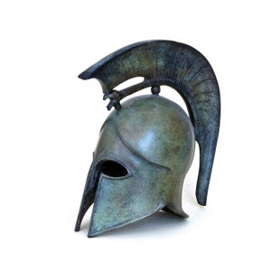 May include: A bronze Greek warrior helmet with a plume on top. The helmet is a replica of an ancient Greek helmet and is a popular decorative item.
