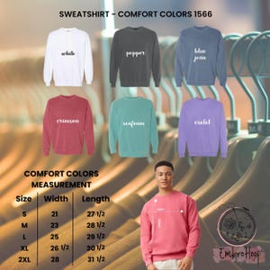 Pode incluir: Exibi&ccedil;&atilde;o de camisolas Comfort Colors em v&aacute;rias cores, incluindo branco, pimenta, azul jeans, carmesim, espuma do mar e violeta. A imagem tamb&eacute;m inclui uma tabela de tamanhos com medidas em cm e uma pessoa a usar uma camisola rosa.