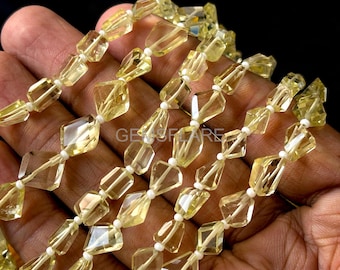 May include: Strands of faceted, light yellow gemstone beads. The beads are strung on white string, with a mix of geometric shapes. The image is well-lit, showing the clarity and color of the stones. The text "GEMSFIARE" is visible.