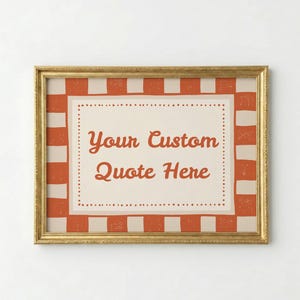 Może przedstawiać: Oprawiony wydruk ze złotą ramą. Grafika przedstawia kremowe tło z napisem "Your Custom Quote Here" w ozdobnej czcionce. Obramowanie ma czerwono-kremowy wzór w kratę.