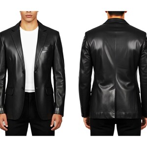 May include: A black leather blazer with a two-button closure, front pockets, and a notched lapel. The image shows both the front and back of the jacket. The blazer is a classic style, suitable for various occasions.