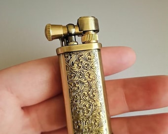 Encendedor de aceite de latón vintage con intrincado grabado floral, estilo trinchera de la vieja escuela.