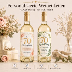 Può includere: Due bottiglie di vino in vetro con etichette personalizzate per un 70° compleanno. L'etichetta sinistra presenta accenti floreali rosa e testo dorato, mentre quella destra mostra foglie di eucalipto verdi e testo dorato. Entrambe riportano il numero 70.