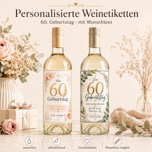 Op de afbeelding: Twee glazen wijnflessen met gepersonaliseerde etiketten voor een 60e verjaardag. Het linker etiket heeft roze bloemaccenten en de tekst 'Zum 60 Geburtstag'. Het rechter etiket bevat groene eucalyptusbladeren en de tekst 'Zum 60 Geburtstag'.