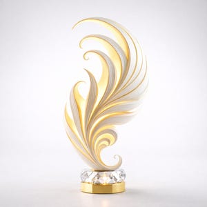 Könnte beinhalten: Eine dekorative Lampe mit einem weißen und goldenen federartigen Design. Die Lampe hat einen Kristallfuß und einen goldfarbenen Metallakzent. Das Licht scheint durch das Federdesign und erzeugt einen warmen Schein. Ein einzigartiger Einrichtungsgegenstand.