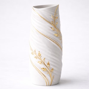 Può includere: Vaso in ceramica bianca con un design testurizzato a spirale e dettagli in foglia d'oro. Il vaso ha una forma alta e slanciata con una parte superiore leggermente inclinata. Linee dorate e motivi a foglie adornano la superficie.