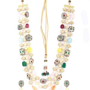 Peut inclure: Un ensemble de collier et boucles d'oreilles assorties à plusieurs rangs. Le collier est composé d'un cordon doré avec un pompon et orné de perles, de pierres précieuses colorées et d'éléments métalliques décoratifs. Les boucles d'oreilles ont un design similaire avec des pierres vertes.