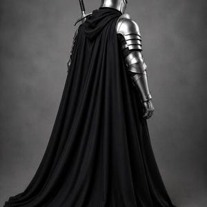 May include: A suit of polished silver metal armor featuring a rounded helmet, segmented shoulder and arm plating, and a long, flowing black hooded cloak. A longsword with a black grip and silver crossguard is strapped to the back of the armor.