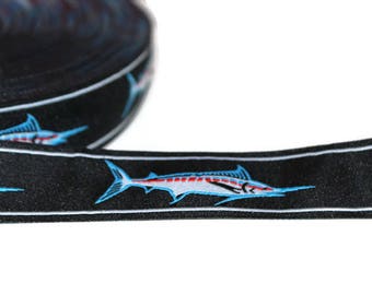 May include: Black and white ribbon with a repeating pattern of blue marlin fish. The ribbon has a white border.