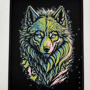 May include: A framed art print with a vibrant wolf illustration. The wolf's fur is depicted in yellow, blue, and green hues, set against a black backdrop. The artwork showcases a detailed, stylized design with floral and geometric patterns.