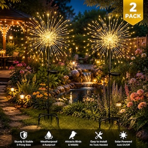 May include: A 2-pack of solar-powered garden lights featuring starburst-shaped LED displays on black metal stakes. Each light has a 5-prong base, a small solar panel, and emits a warm yellow glow, designed for outdoor use in a garden setting.