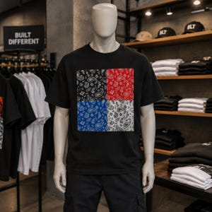Puede incluir: Una camiseta negra de manga corta con un gran gráfico cuadrado en el pecho. El gráfico está dividido en cuatro cuadrantes, cada uno con un patrón de bandana de cachemira de distinto color en negro, rojo, azul y blanco sobre fondo negro.