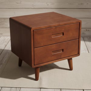 May include: A mid-century modern style nightstand in a warm brown finish. The nightstand features two drawers with rectangular pulls and tapered legs. The rounded edges and clean lines give it a minimalist aesthetic.