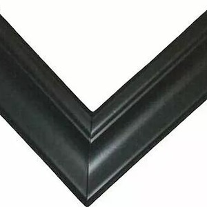 Op de afbeelding: Een hoek van een zwarte fotolijst met een afgeschuinde rand. De lijst is gemaakt van een donker, solide materiaal en heeft een klassiek, elegant ontwerp. De lijst is leeg, met een witte achtergrond.