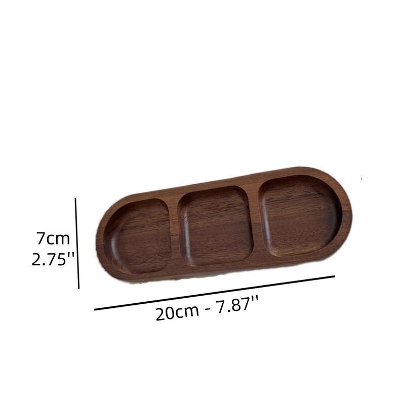 May include: A wooden serving tray with three compartments. The tray is oval-shaped and measures 20cm (7.87") long and 7cm (2.75") wide. The tray is made of dark brown wood.