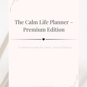 Puede incluir: Un planificador rosa claro titulado "The Calm Life Planner - Premium Edition". El texto "A minimal system for clarity, focus & balance" está debajo. El planificador tiene detalles florales y un símbolo de corazón.