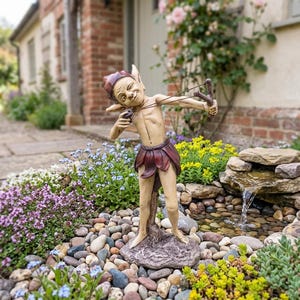 May include: A whimsical garden statue of a mischievous elf aiming a slingshot. The elf is depicted with pointed ears, a red cap, and a brown skirt. The statue is set in a garden with colorful flowers and a small water feature.