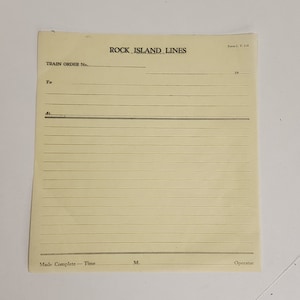 May include: A vintage train order form from the Rock Island Lines. The cream-colored paper has horizontal lines for writing and the text "ROCK ISLAND LINES" at the top. The form includes fields for "TRAIN ORDER No.", "To", and "At".