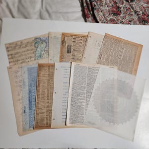 May include: A collection of vintage ephemera, including aged paper documents, newspaper clippings, and pages with handwritten notes. The papers vary in color, from cream to tan, and some feature printed text and illustrations. The assortment suggests a historical or archival theme.