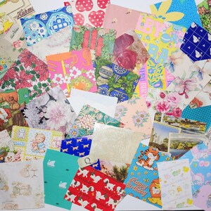May include: A collection of vintage greeting cards and decorative papers. The assortment includes floral, animal, and geometric patterns in various colors. Some cards feature text like "Happy Birthday" and "Best Wishes".
