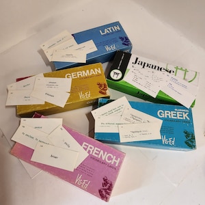 May include: A collection of six vintage vocabulary card sets in different languages, including Latin, German, Japanese, Greek, and French. Each box features a colorful design and the Vis-Ed logo.