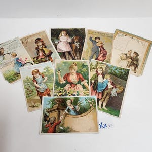 May include: A collection of nine vintage-style rectangular paper trade cards featuring colorful illustrations of children and adults in historical clothing, with various outdoor scenes, floral motifs, and printed text, arranged in a scattered layout.