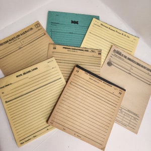 May include: A collection of vintage train order forms from different railroad companies, including Western Maryland Railway Co., Penn Central Co., Missouri-Kansas-Texas R.R. Co., Rock Island Lines, and The Pennsylvania Railroad. The forms are all yellowed with age and have handwritten numbers on them.