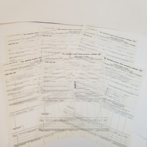 May include: A stack of vintage transit freight waybills from the Missouri-Kansas-Texas Railroad Company. The forms are printed on white paper with black ink and include fields for car initials, car number, date of issue, destination, and weight. The forms are dated 1950s.