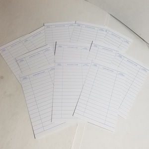 May include: A stack of white paper forms with blue lines and the text "Borrower's Name", "Date Loaned", and "Date Returned".