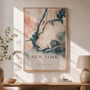 May include: A framed watercolor map print of New York City, USA. The artwork features a blend of pink, blue, and beige hues, with the city's layout and text that reads "NEW YORK" and "Where it all began."