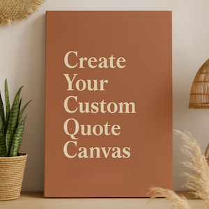 Puede incluir: Un lienzo de color terracota con el texto "Create Your Custom Quote Canvas" en crema. El lienzo se muestra sobre una superficie de madera, con una planta en maceta y una lámpara tejida en el fondo, creando un ambiente cálido.